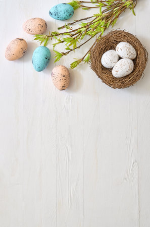 Branches with green leaves and easter eggs on a light background. Happy easter flat lay conceptの写真素材