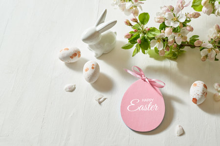 Holiday composition with spring flowers and easter eggs, white bunny on a light background. Happy easter concept with copy spaceの写真素材