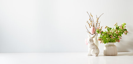 Spring flowers in a vase and easter bunny on a light background. Easter background with copy spaceの写真素材