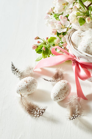 Holiday composition with spring flowers and easter eggs in basket on a light background. Happy Easter backgroundの写真素材