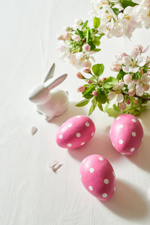 Holiday composition with spring flowers and easter eggs, white bunny on a light background. Happy easter concept with copy spaceの写真素材