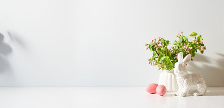 Spring flowers in a vase and easter eggs on a light background. Easter background with copy spaceの写真素材