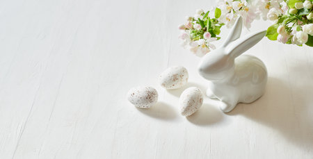 Holiday composition with spring flowers and easter eggs, white bunny on a light background. Happy easter concept with copy spaceの写真素材