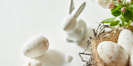 Holiday composition with spring flowers and easter eggs, white bunny on a light background. happy easter backgroundの写真素材