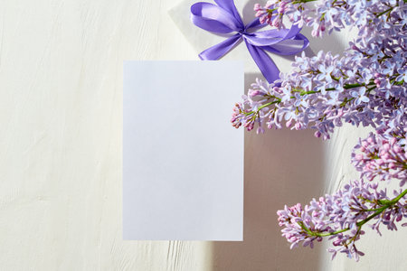 Mockup white greeting card with lilac branches on a white backgroundの写真素材