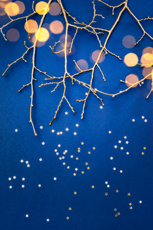 Flat lay christmas composition with golden branches and christmas decorations, garland on a blue background. Winter merry christmas holiday greeting cardの写真素材