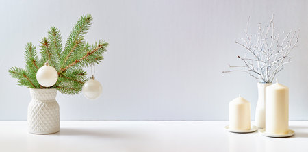 Christmas, New Year home decor. Empty white wall mock up with green fir branches in a vase on a white table. Mock up for display worksの写真素材