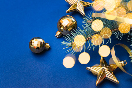 Christmas composition with fir branches and Christmas decorations, garland on a blue background. Winter merry christmas holiday greeting cardの写真素材