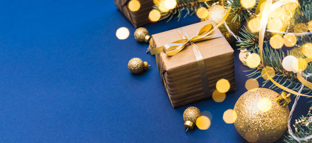 Christmas composition with fir branches and Christmas ball, garland, gift box on a blue background. Winter merry christmas holiday greeting cardの写真素材