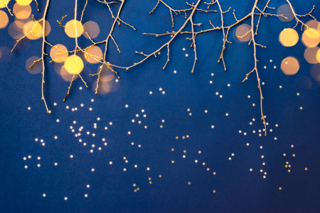 Flat lay christmas composition with golden branches and christmas decorations, garland on a blue background. Winter merry christmas holiday greeting cardの写真素材