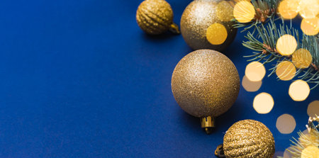 Christmas composition with fir branches and Christmas ball, garland on a blue background. Winter merry christmas holiday greeting cardの写真素材