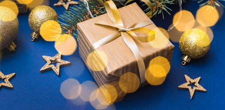 Christmas composition with fir branches and Christmas decorations, garland, gift box on a blue background. Winter merry christmas holiday greeting cardの写真素材