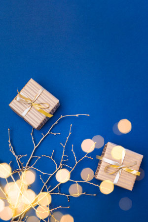Flat lay christmas composition with golden gift box and christmas decorations, garland on a blue background. Winter holiday background with copy spaceの写真素材