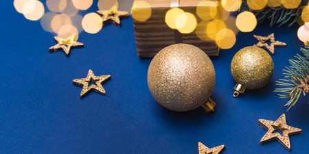 Christmas composition with fir branches and Christmas decorations, garland, gift box on a blue background. Winter merry christmas holiday greeting cardの写真素材