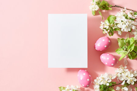 Mockup invitation or blank greeting card with spring flowers and easter eggs on a pink backgroundの写真素材