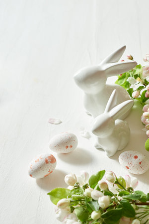 Holiday composition with spring flowers and easter eggs, white bunny on a light background. Happy...