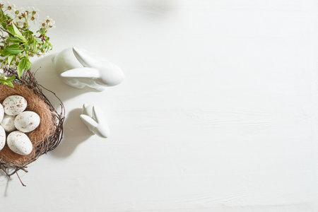 Holiday composition with spring flowers and easter eggs on a light background. Happy easter flat lay concept with copy spaceの写真素材