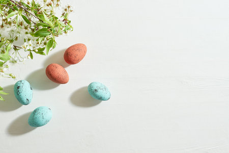 Holiday composition with spring flowers and easter eggs on a light background. Happy easter flat lay concept with copy spaceの写真素材