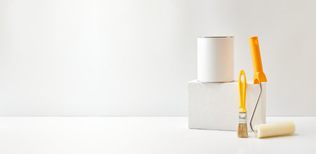 Geometric podium or pedestal with paint can, brush, sponge roller on a white background. Mock up for display worksの写真素材