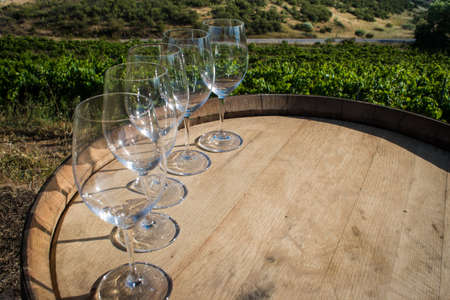 several wine glasses on a wooden barrelの写真素材