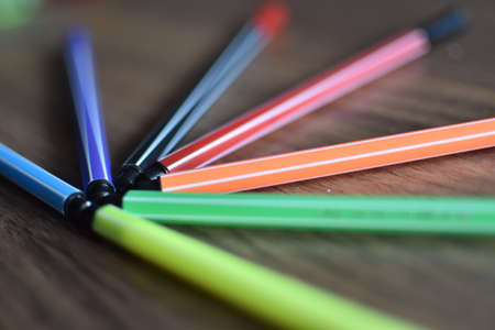 colored markers on wooden background