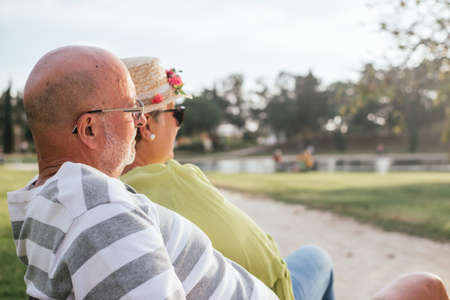 pensioners couple close-up sitting on a park