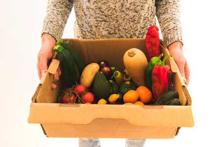 delivery man with a box of ecological fruits and vegetablesの写真素材