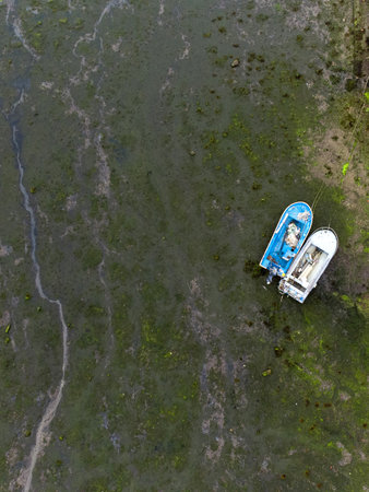 Drone view of two fishermanss boats stranded on the sand