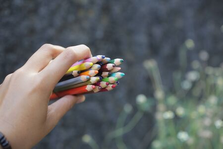 Bunch of colored pencil in young woman hands.の写真素材
