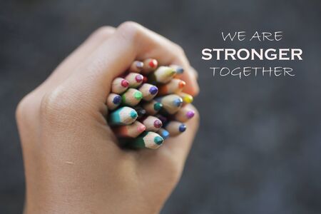 Inspirational quote - We are strong together. With Bunch of colored pencils in hand.の写真素材