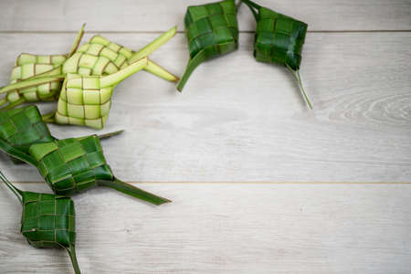 aKetupat background on white wooden board. Ketupat frame with copy paste for your text or design....