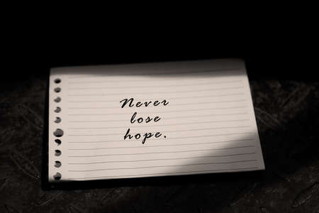 Inspirational motivational quote - Never lose hope. A self simple note or self reminder on white paper with natural light background.の写真素材