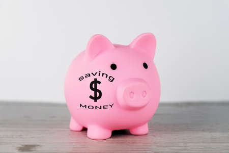 Saving money and investment concept with pink piggy bank and dollar currency symbol on the table. Business and personal financial planning.の写真素材