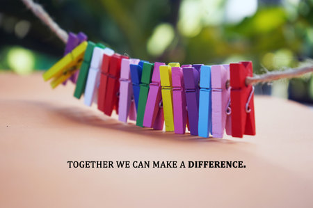 Inspirational quote - Together we can make a difference. With colorful wooden paper clips on rope on...