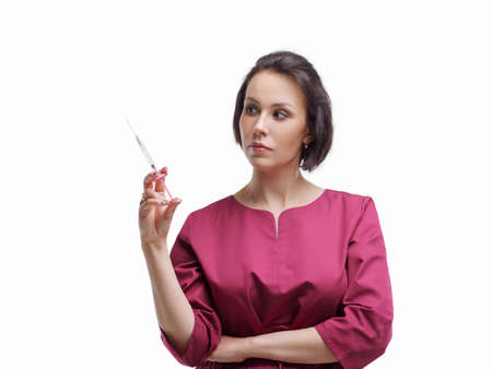woman doctor with a syringe in her hand. Portrait medium plan. A syringe in the hand of a woman on a white background. Photo of the doctor on the isolateの写真素材