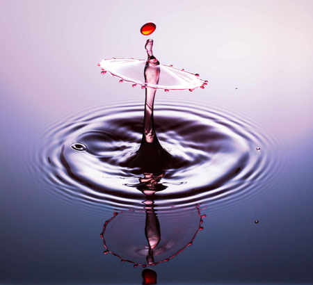 Water drop photography, one or two drops of water dropped from height into water and captured as they hit the water or collide with each other.の写真素材