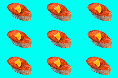 Salmon fillet of red fish on a turquoise background with a slice of lemon. Pattern, prints.