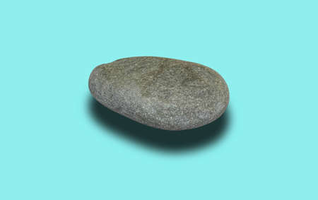 Gray sea smooth stone isolated on a turquoise background. Close-up, selective shot.