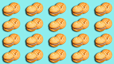 Seamless pattern with round cookies with filling on a turquoise background. Pastry ornament,...