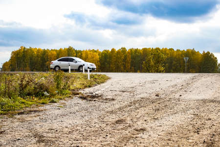 Highway between a beautiful yellow autumn forest, where a car passes at speed. Landscape.の写真素材