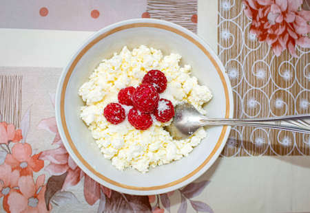 Fresh cottage cheese in a Cup with fresh raspberries. Healthy and satisfying snack. The view from...