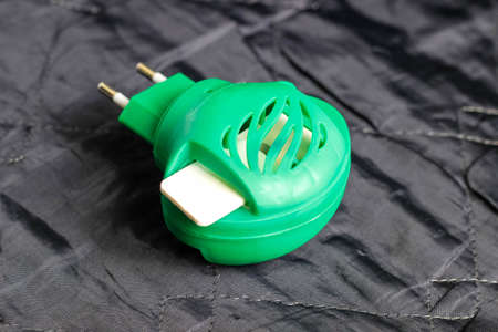 The fumigator with an inserted disc from the mosquitoes on a black background. Selective shot.