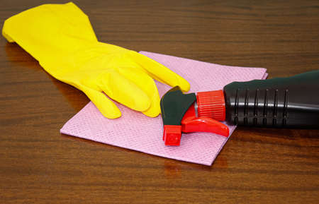 On the table are cleaning products, a rubber glove and a napkin. The concept of disinfection and...