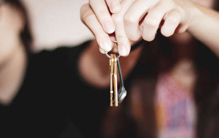 Two people hold the keys to the house with their hands outstretched. The concept of buying an...