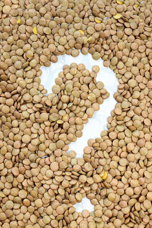 Lentil background with a question mark in the center. The texture of the products. Vertical image.の写真素材