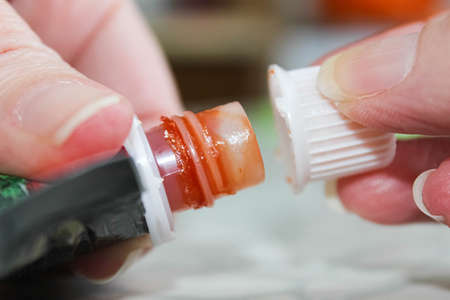 Hands that close the package with the started ketchup. Selective focus.の写真素材