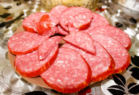 Sliced smoked salami sausage is spread out on a plate. Close-up, selective shot.の写真素材