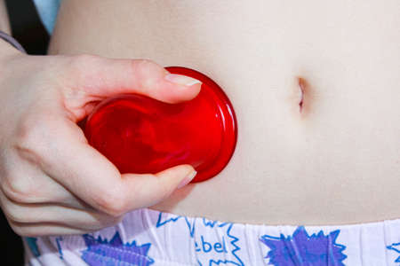 Massage with vacuum banks at home on the stomach.