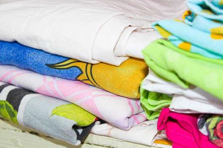 Colorful bed linen in the closet on the shelf. Close up.