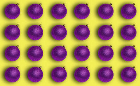 Pattern with a Christmas shiny purple ball on a yellow background. Template for backgrounds,...